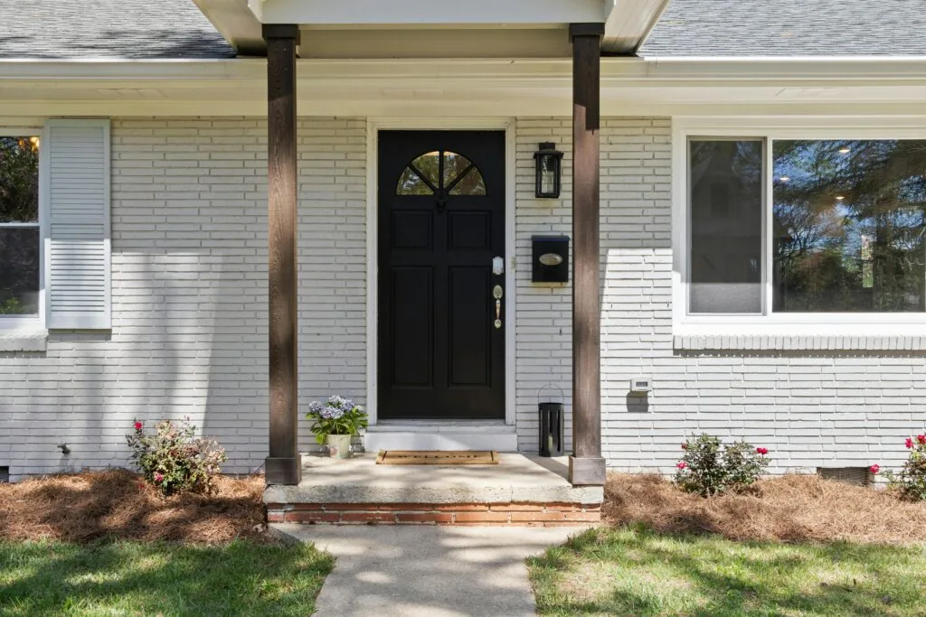 Front entrance of white painted brick house